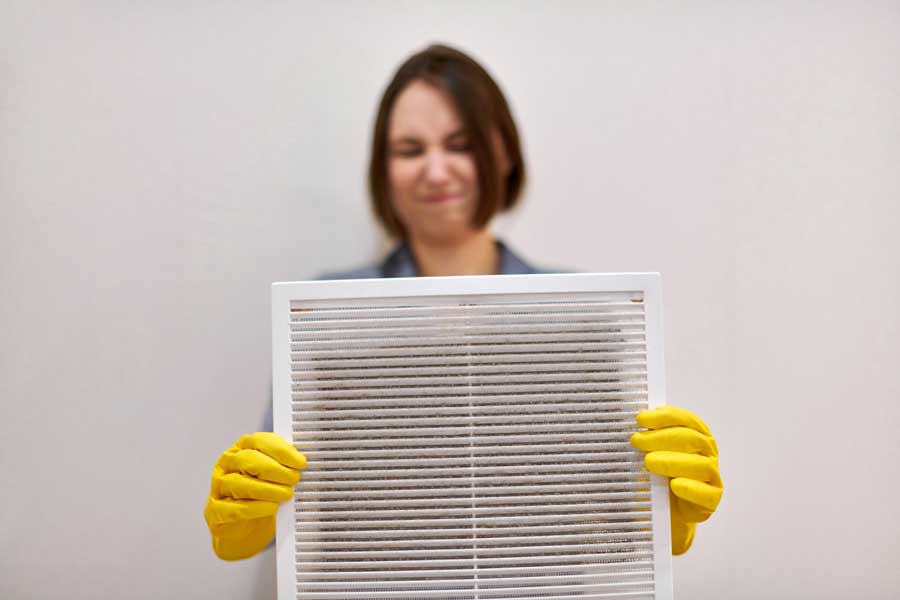 A woman holding a dirty air vent